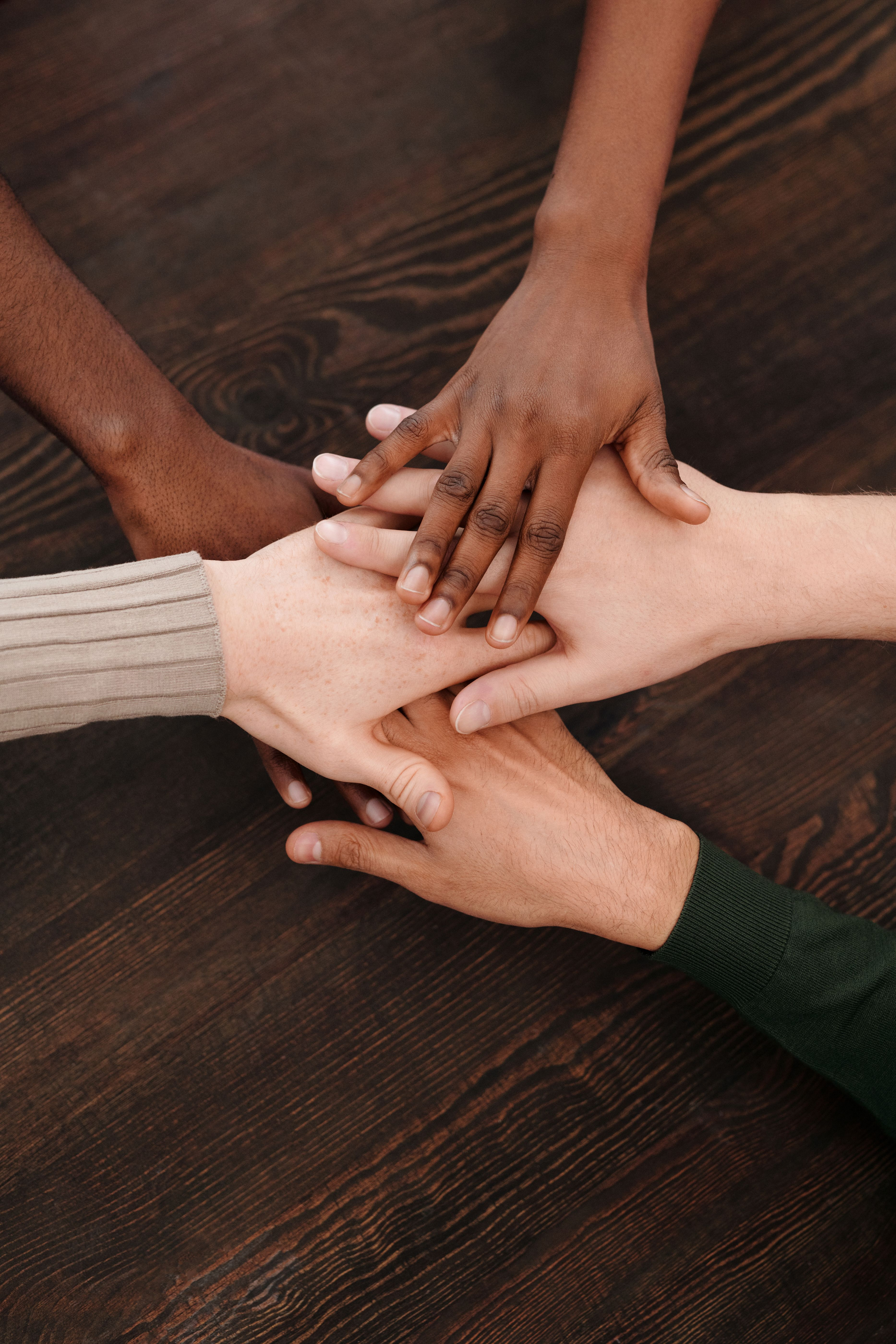 Plusieurs mains posées ensemble pour représenter la diversité, le respect et la solidarité